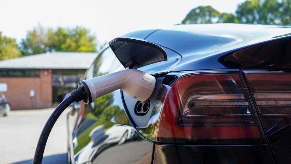 An electric vehicle plugged into its charger.