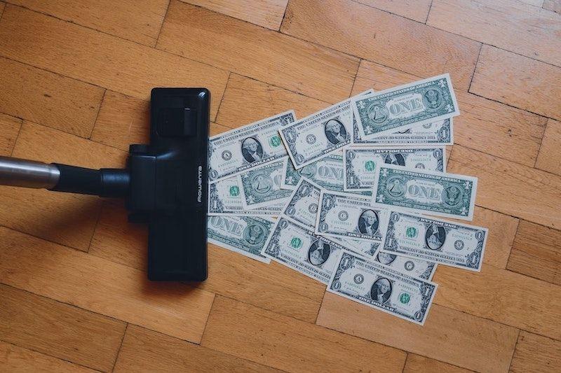A vacuum sucking up money